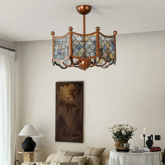 Bronze geometric paneled chandelier with multi-colored glass shades hanging in a living room above a couch.