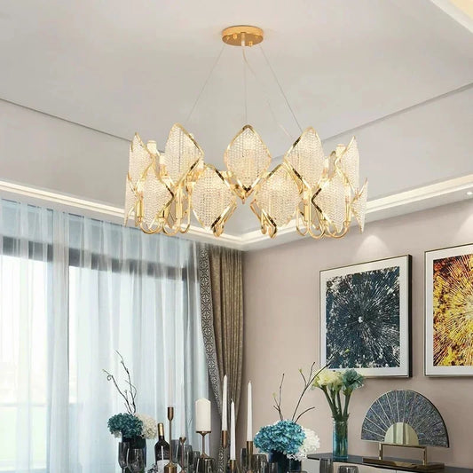 Gold tiered chandelier with clear crystal accents hanging above a dining table.