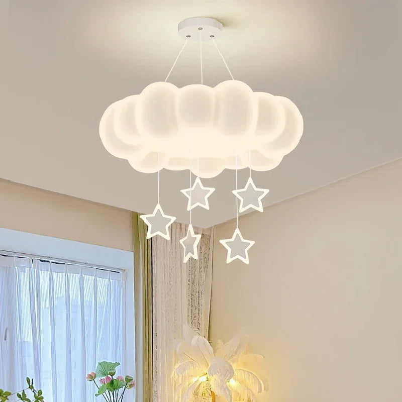 A white cloud-shaped pendant light with five white stars hanging from it, shown in a bright room.