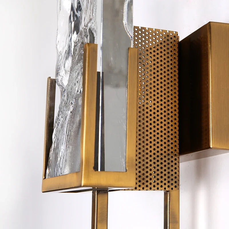 Decorative wall light fixture with gold and metallic finishes on a white background