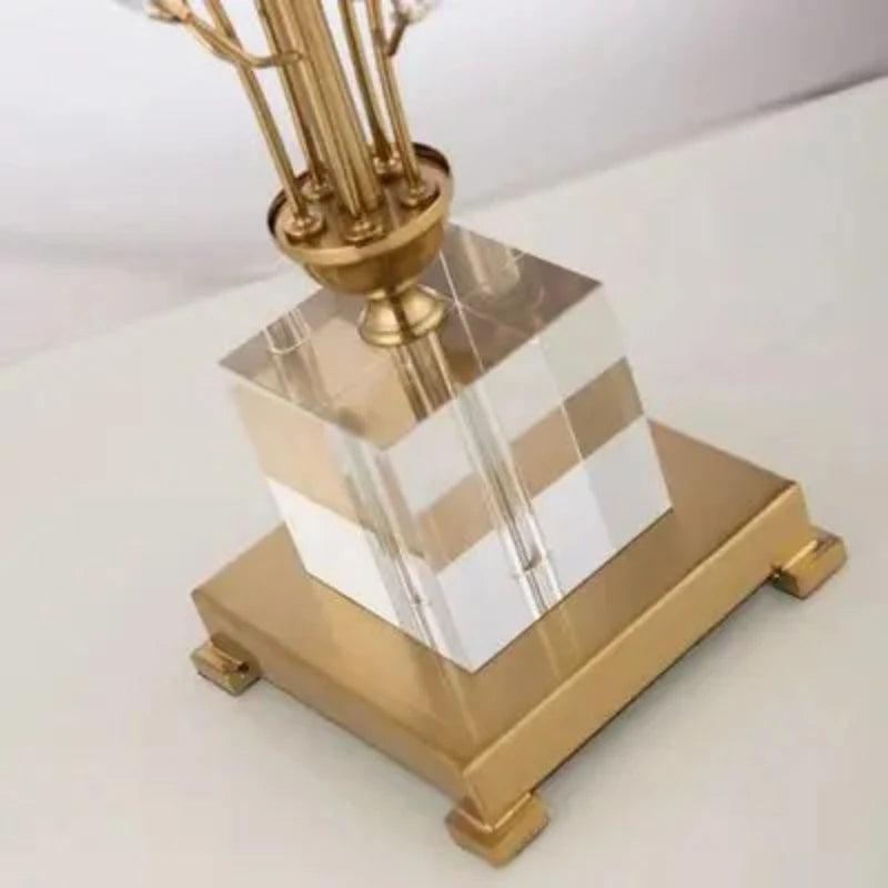 Decorative lamp with gold base and clear glass shade on a white background