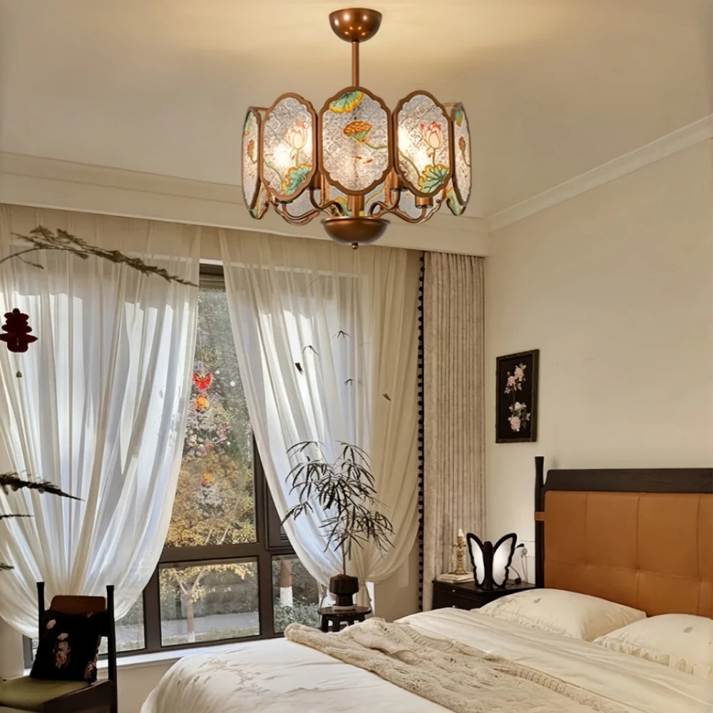 Copper frame chandelier with floral acrylic panels in a bedroom setting with sheer curtains.