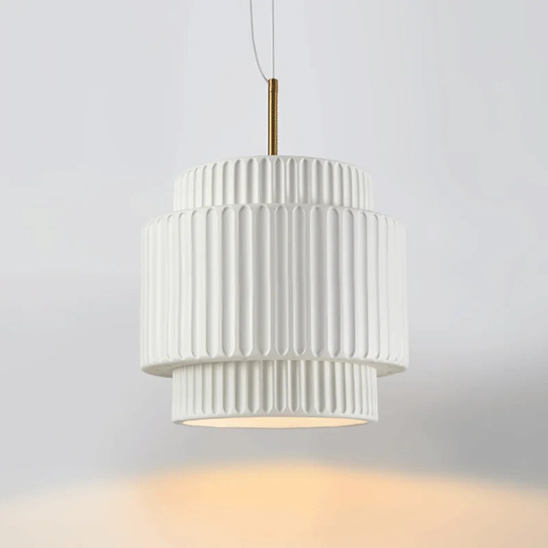 White tiered resin pendant light against a white background