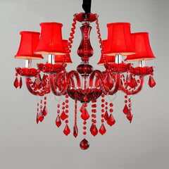 Red crystal chandelier with six fabric shades and cascading crystal droplets, against a grey background.