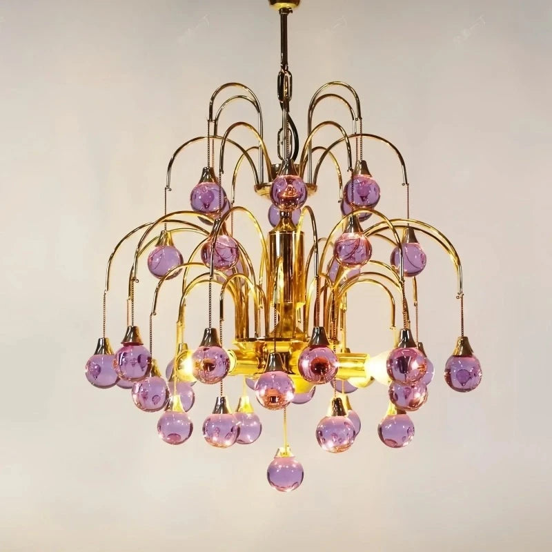 Close-up view of the gold metalwork and purple droplet crystals on a cascading chandelier.