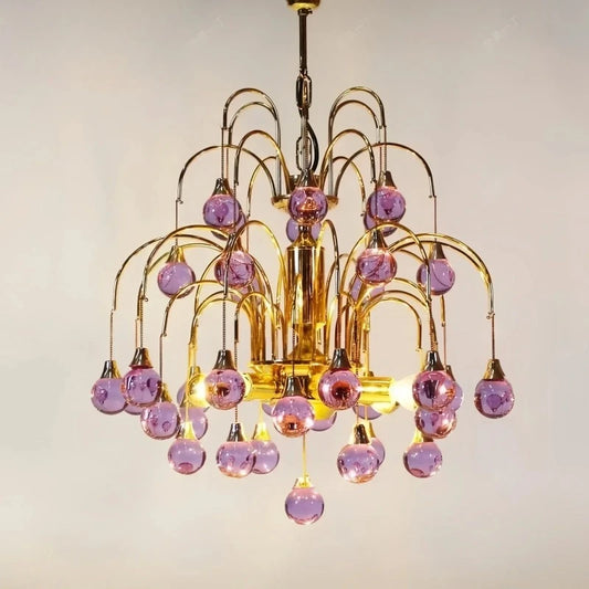 Close-up view of the gold metalwork and purple droplet crystals on a cascading chandelier.