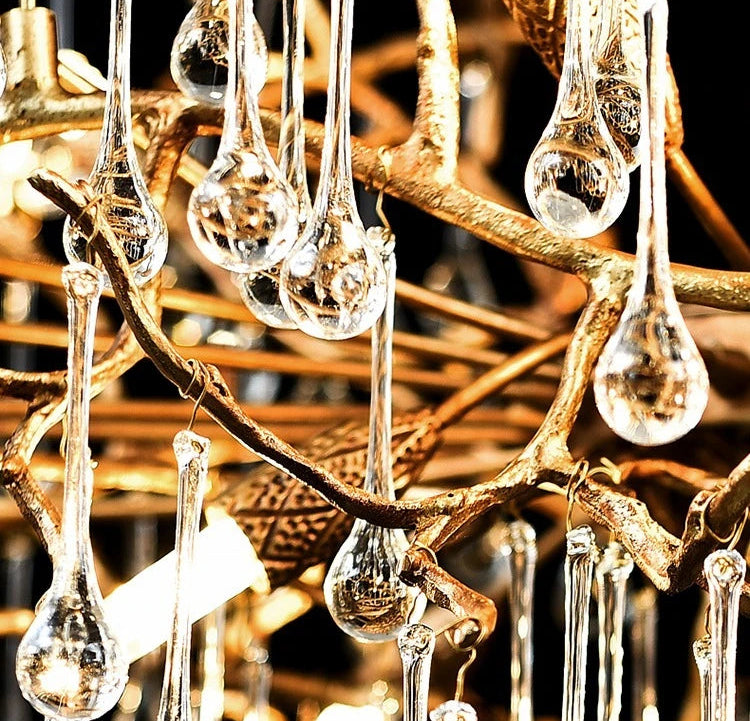 Close-up of a decorative chandelier with gold branches and clear glass droplets.