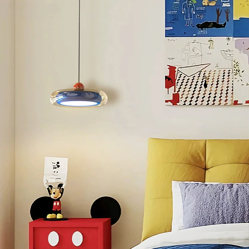 A different angle of the blue oval pendant light with red accent in a colorful room setting.