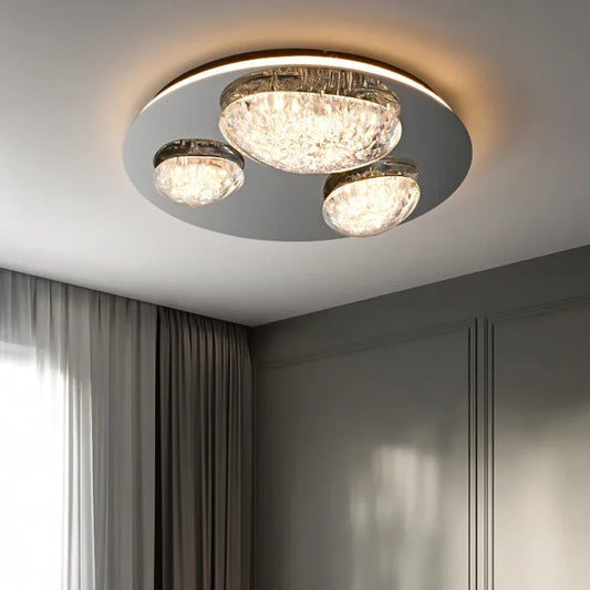 Close-up of a single clear crystal globe on a polished chrome ceiling light fixture, showing the textured surface.