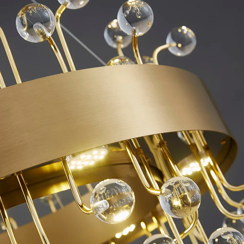Detailed view of the gold finish and clear crystal elements on a chandelier.
