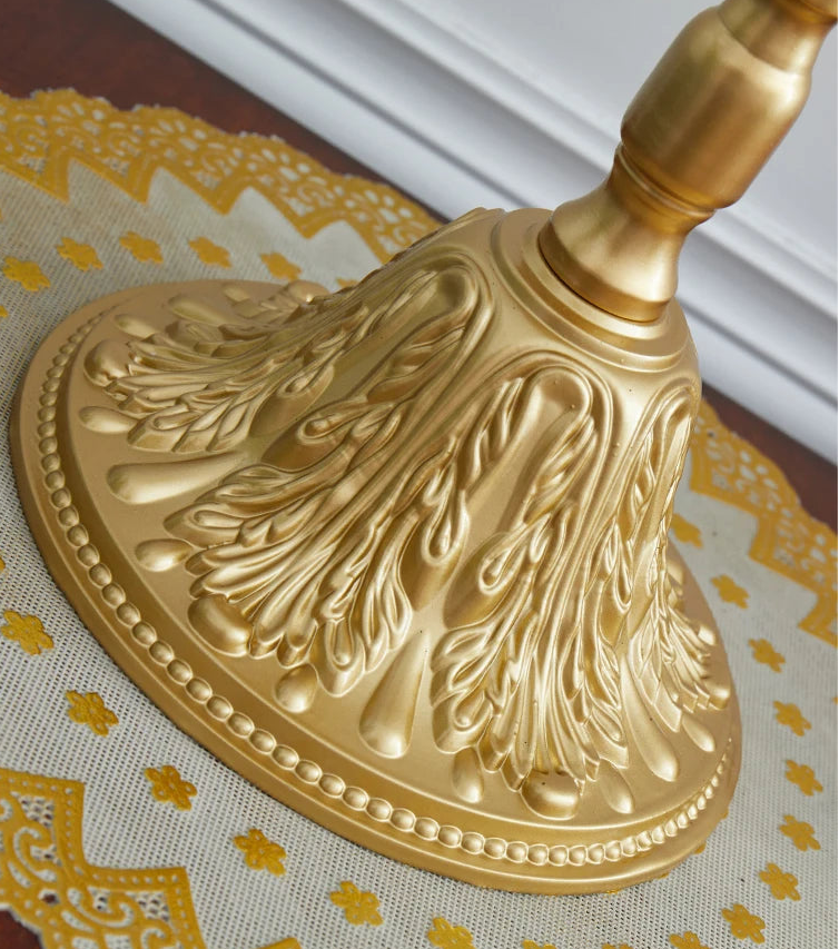 Decorative gold broom on a patterned surface