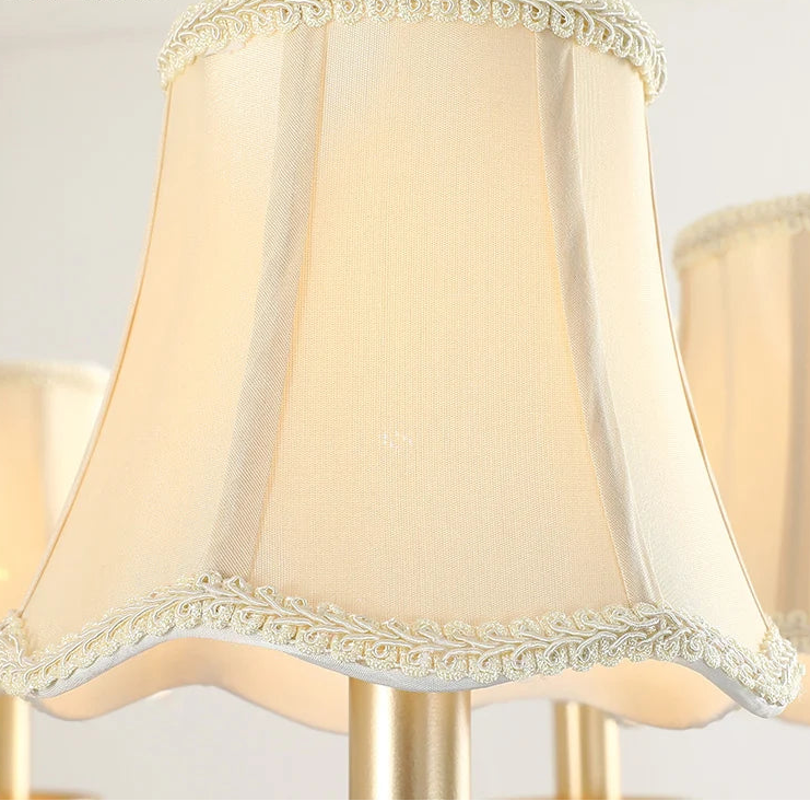 Beige lampshade with decorative trim on a light background.