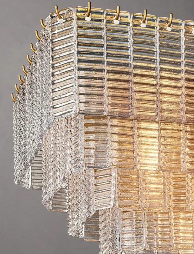 Decorative chandelier with glass panels and gold accents on a gray background