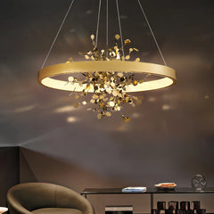 Another view of the gold ring pendant light with floral accents, showcasing its illumination.