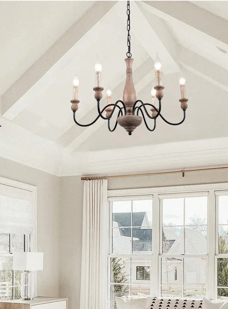 Chandelier hanging in a room with large windows and neutral decor