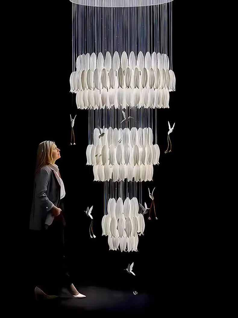 Woman looking at a large, intricate chandelier with birds on a black background