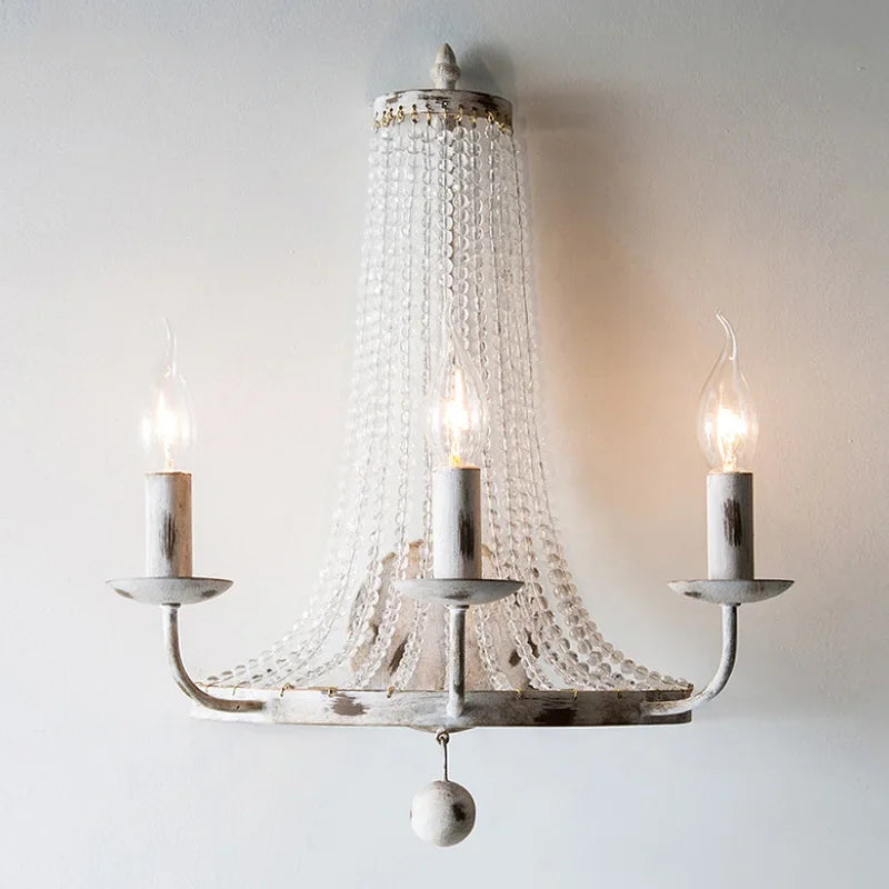 Decorative chandelier with three candle-style lights on a plain background