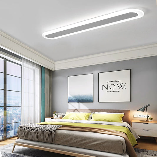 White and grey oval-shaped ceiling light illuminating a bedroom with a city view.