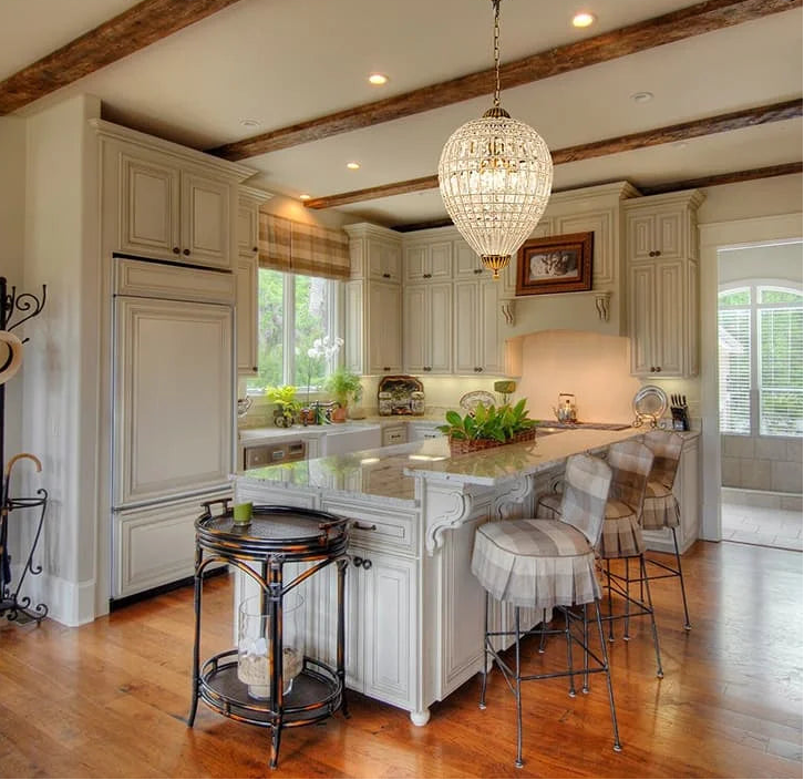 Modern kitchen with a large crystal chandelier hanging from the ceiling.