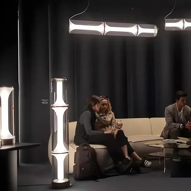 Two people sitting on a couch in a modern room with stylish lamps and decor.
