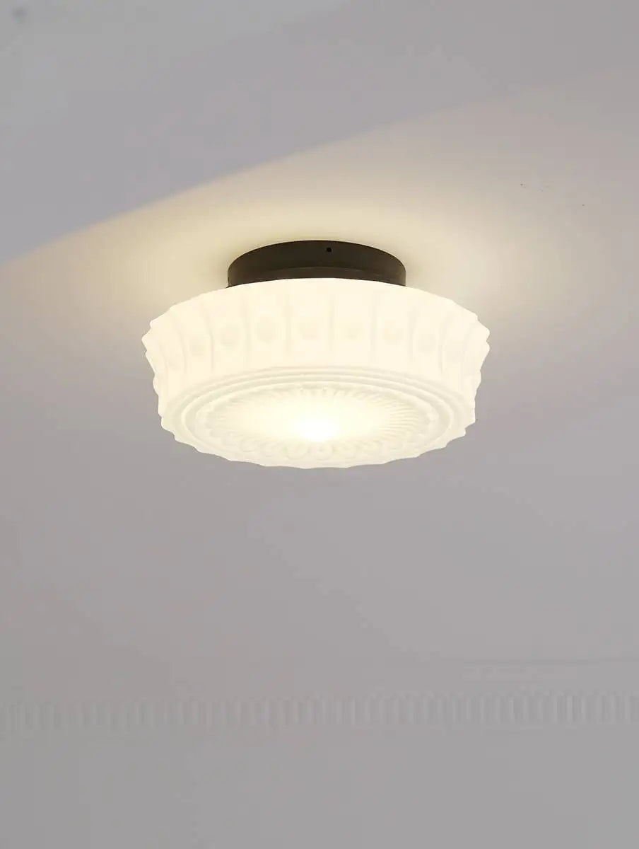 Ceiling light fixture with white glass shade on a gray ceiling