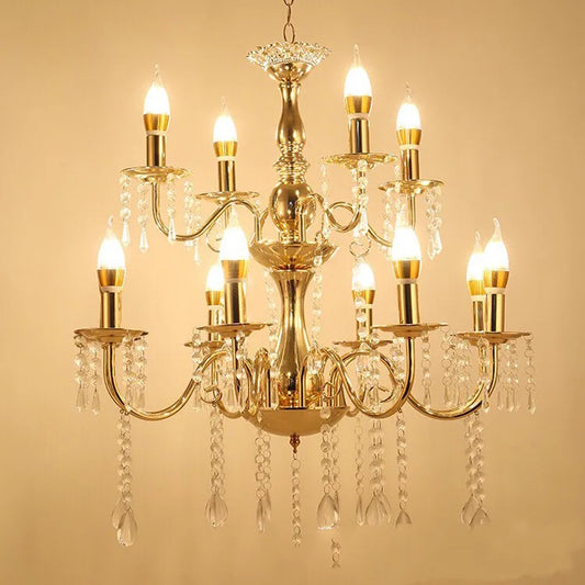 A grand, multi-tiered gold chandelier with candelabra-style arms adorned with cascading clear crystals, illuminated with warm white LED bulbs against a cream background.