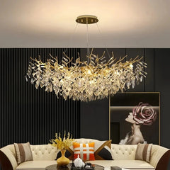 A wide shot of a living room featuring a gold crystal branch chandelier hanging above a sofa.