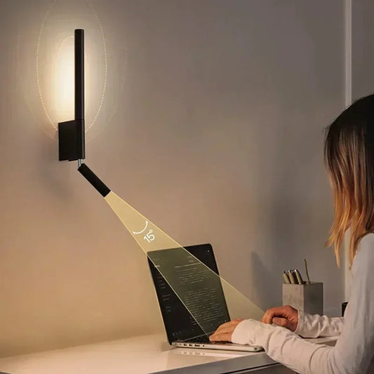 A person using a laptop, illuminated by a black adjustable LED wall sconce demonstrating the 15-degree angle.