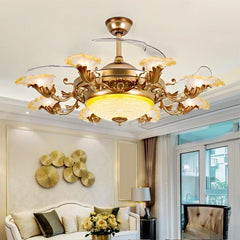 A lifestyle shot of a gold ceiling fan light with floral crystal details, installed in a living room above a sofa.