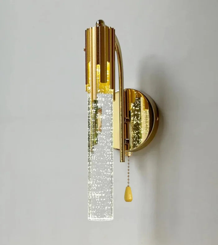 Gold wall sconce with crystal accents on a gray background