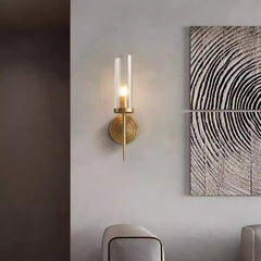 Wall sconce with a textured wall art piece on a gray wall.