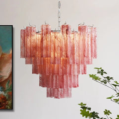 A tiered chandelier with many vertical, translucent, pinkish-red glass rods hanging from a chrome base, illuminated from within.