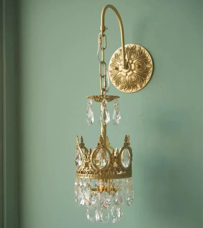Gold chandelier with crystal accents on a light green wall