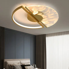 Gold and white circular ceiling light with feather pattern glass shade, seen from a different angle in a bedroom.
