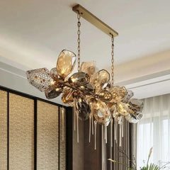 A wide shot of a gold chandelier with cascading faceted crystals hanging from a ceiling.