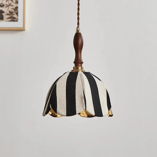 Close-up view of the black and white striped fabric pendant light, highlighting the texture of the fabric and the brass fittings.