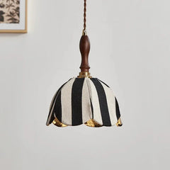 Close-up view of the black and white striped fabric pendant light, highlighting the texture of the fabric and the brass fittings.