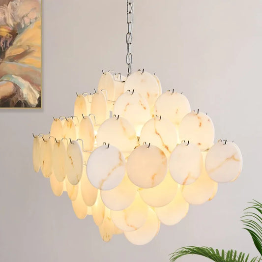 Illuminated white faux alabaster marble disc chandelier with a polished chrome frame, showcasing its layered design.
