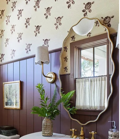 Bathroom interior with wooden vanity, sink, and decorative elements.