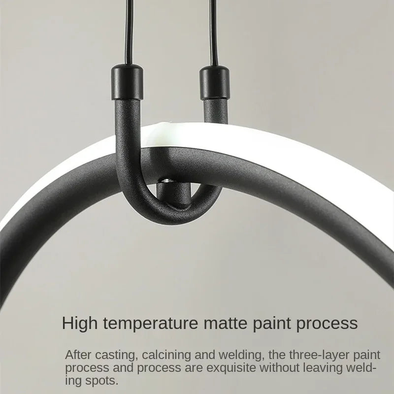 Modern pendant light with black metal fixture on a neutral background