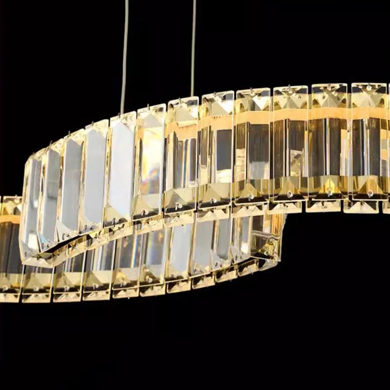 Gold rectangular chandelier against a black background