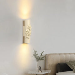 Close-up of a beige cylindrical wall sconce with sculpted roses.