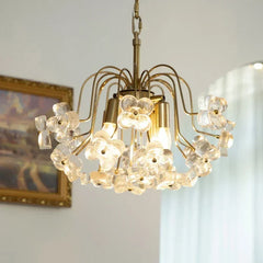 Gold-tone chandelier with clear glass floral accents hanging from a chain.