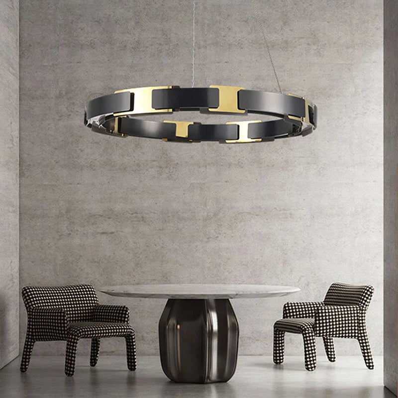 Modern chandelier hanging above a dining table with two chairs in a minimalistic room.