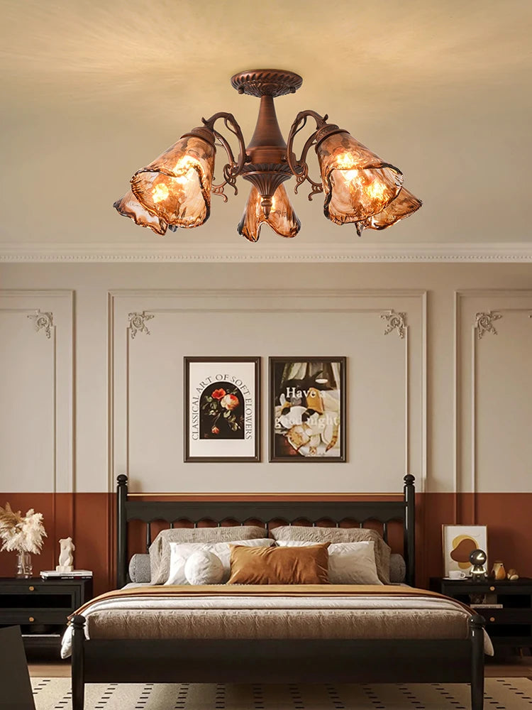 A semi-flush mount ceiling light with a brushed bronze finish and amber stained glass shades, seen from a slightly lower angle.