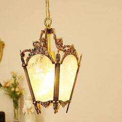 The polished copper floral glass pendant light is shown in a softly lit interior, with a hint of flowers in the background.