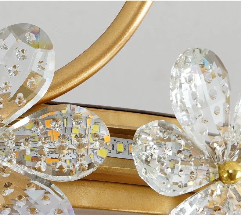 Close-up of decorative crystal elements with gold accents on a light gray background