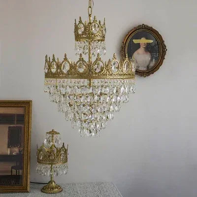 Gold chandelier with crystal accents in a room with framed pictures on the wall.