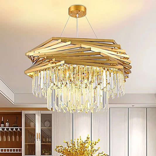 A golden geometric chandelier with cascading crystal prisms hangs from the ceiling in a dining room setting with a wine rack visible.