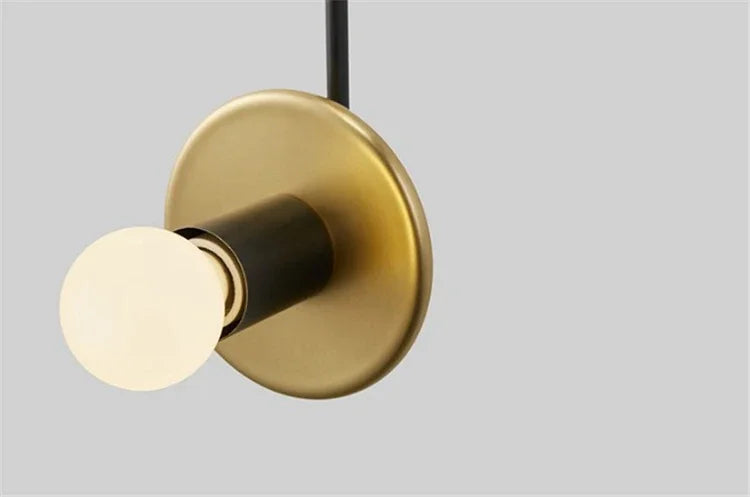 Modern light fixture with gold and black design on a gray background